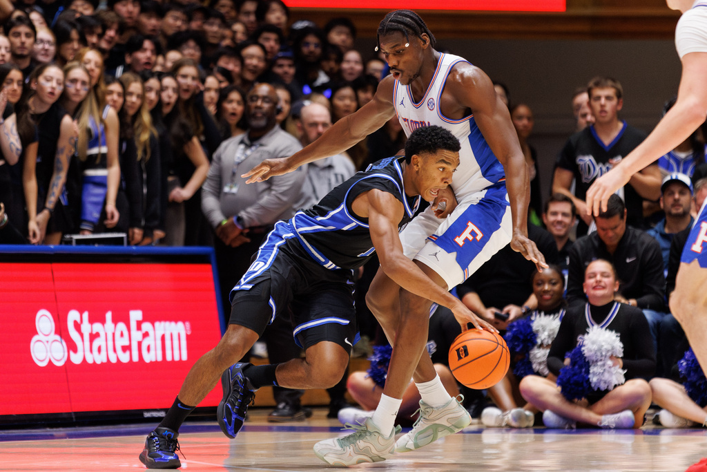 Duke's Caleb Foster (1) handles the ball as Florida's Rueben Chinyelu, right, defends during the first half of an NCAA college basketball game in Durham, N.C., Tuesday, Dec. 2, 2025. (AP Photo/Ben McKeown)