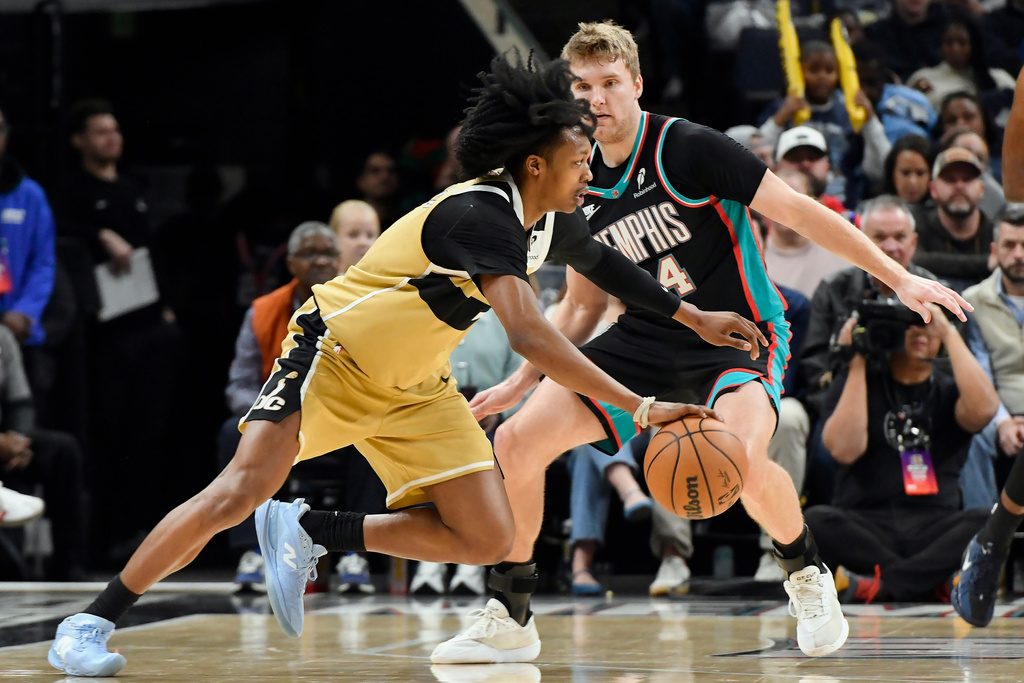 Washington Wizards guard Bub Carrington drives against Memphis Grizzlies guard Cam Spencer (24) in the first half of an NBA basketball game, Saturday, Dec. 20, 2025, in Memphis, Tenn. (AP Photo/Brandon Dill)