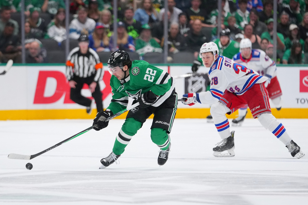 Dallas Stars center Mavrik Bourque (22) breaks away with the puck as New York Rangers left wing Adam Sykora (38) chases him during the first period of an NHL hockey game Saturday, April 11, 2026, in Dallas. (AP Photo/Julio Cortez)