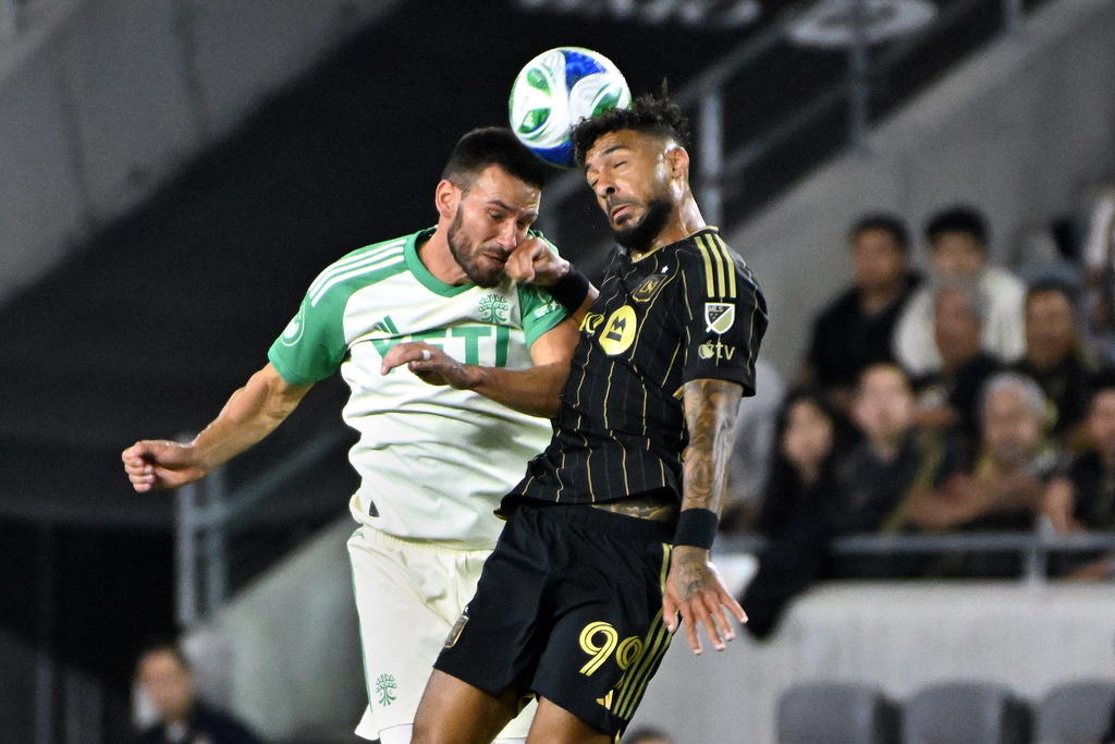 Austin FC defender Brendan Hines-Ike, left, vies for a header with LAFC forward Denis Bouanga during the first half of Game 1 in the first round of MLS soccer's Western Conference playoff Wednesday, Oct. 29, 2025, in Los Angeles. (AP Photo/Wally Skalij)