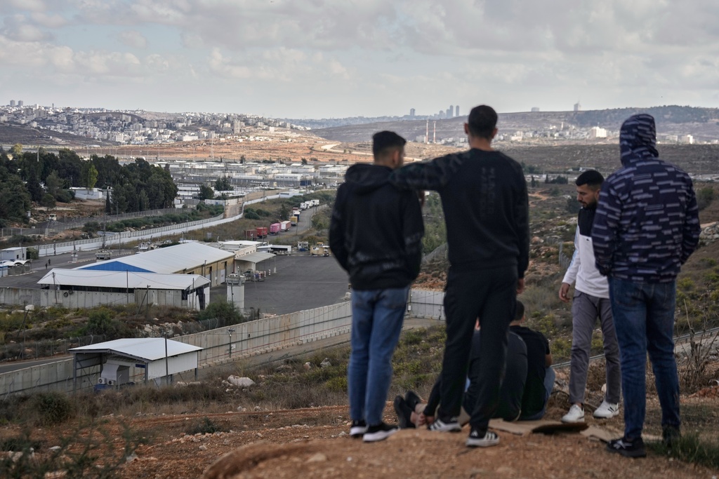 Palestinians look at the Israeli Ofer prison in the West Bank city of Beitunia, Monday Oct. 13, 2025, awaiting the release of Palestinian prisoners as part of a swap for Israelis held hostage in Gaza.(AP Photo/Majdi Mohammed)