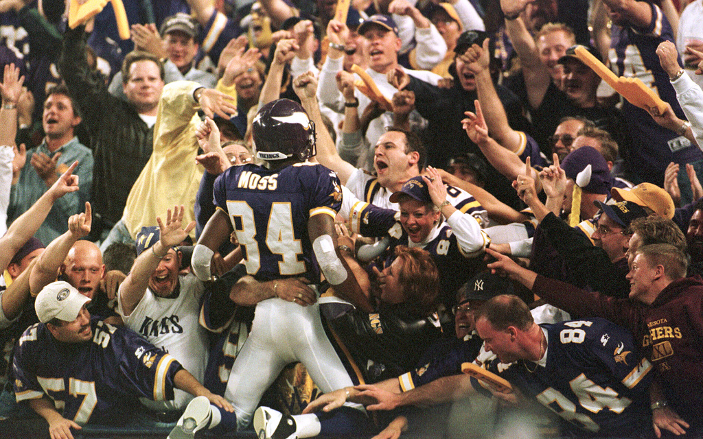 FILE - Minnesota Vikings wide receiver Randy Moss (84) jumps into the crowd to celebrate his 42-yard touchdown pass from Daunte Culpepper during the fourth quarter of an NFL football game against the Tampa Bay Buccaneers, in Minneapolis, Oct. 9, 2000. (AP Photo/Paul Battaglia, File)