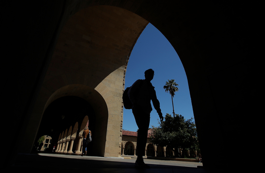 FILE - Pedestrians walk on the campus at Stanford University April 9, 2019, in Stanford, Calif. (AP Photo/Jeff Chiu, File)