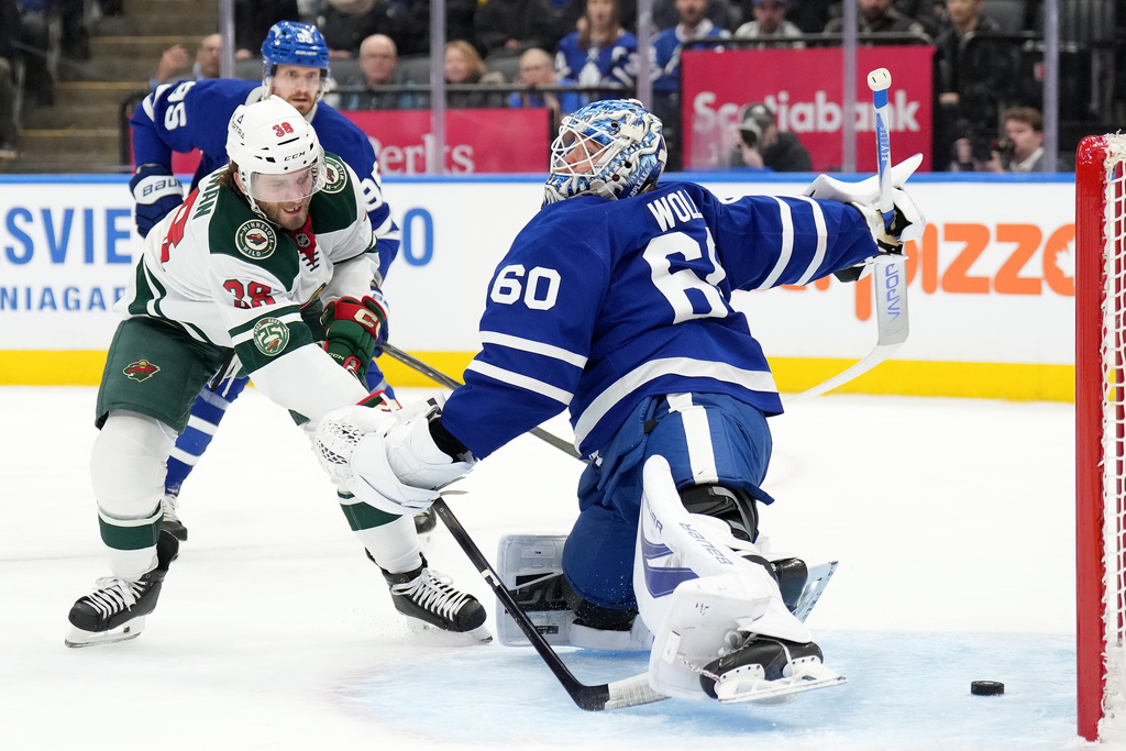 Minnesota Wild forward Ryan Hartman (38) scores past Toronto Maple Leafs goaltender Joseph Woll (60) during first-period NHL hockey game action in Toronto, Monday, Jan. 19, 2026. (Nathan Denette/The Canadian Press via AP)