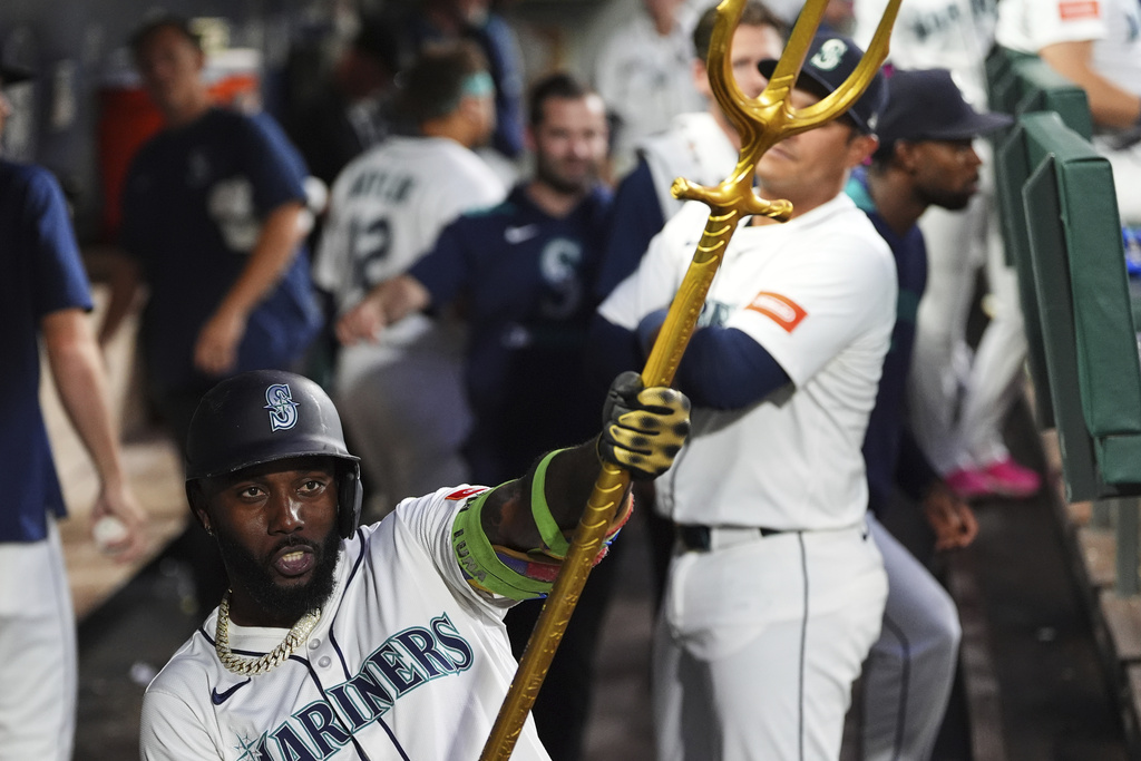 Seattle Mariners' Randy Arozarena celebrates with the trident in the dugout after hitting a solo home run against the Athletics during the sixth inning of a baseball game Saturday, Aug. 23, 2025, in Seattle. (AP Photo/Lindsey Wasson)