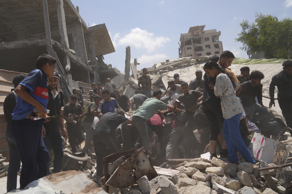 Palestinians struggle to collect humanitarian aid airdropped by parachutes into Gaza City, northern Gaza Strip, Thursday, Aug. 7, 2025. (AP Photo/Jehad Alshrafi)
