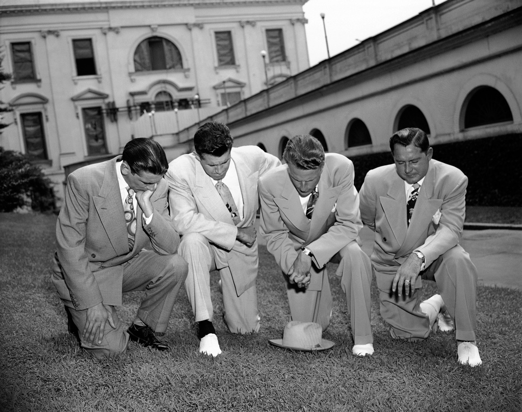 FILE - Evangelist Billy Graham, second from right, kneels with, from left, Jerry Beavan, Clifford Barrows and Grady Wilson, on the White House lawn in Washington, July 14, 1950, praying for President Truman in his handling of the Korean crisis. (AP Photo)