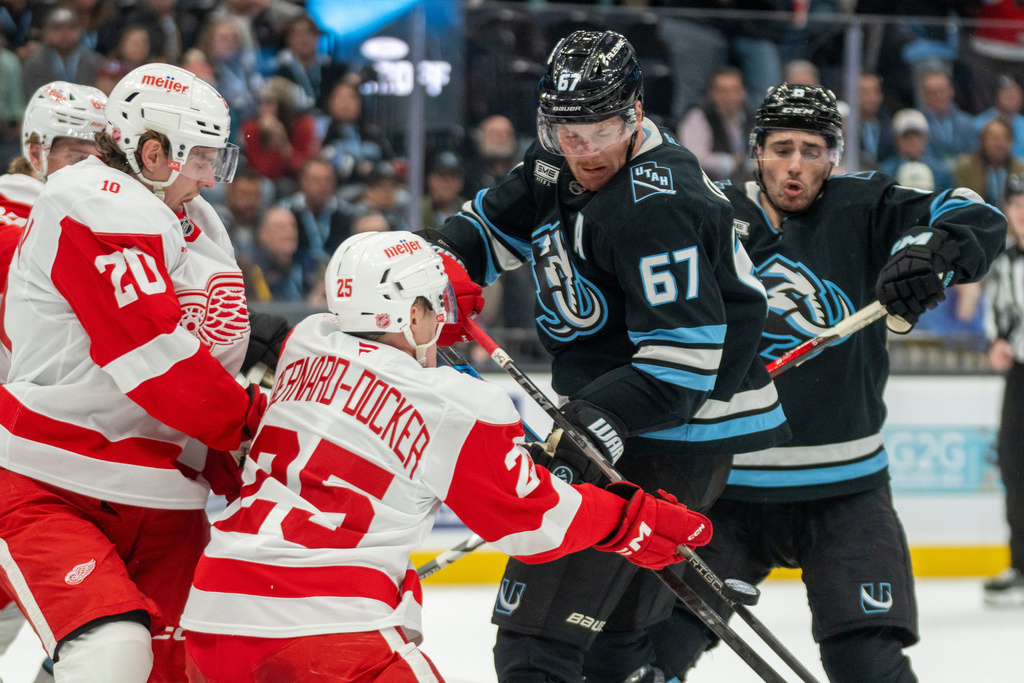 Detroit Red Wings defensemen Albert Johansson (20) and Jacob Bernard-Docker (25) go for the puck along with Utah Mammoth left wing Lawson Crouse (67) Mammoth center Nick Schmaltz (8) during the first period of an NHL hockey game Wednesday, Feb. 4, 2026, in Salt Lake City. (AP Photo/Rick Egan)