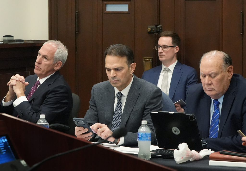 Defendants ex-FirstEnergy Senior Vice President Michael Dowling, left, defense attorney George Stamboulidis and former FirstEnergy CEO Chuck Jones, right, follow a live transcript of an in chamber conference before a hearing in Summit County Common Pleas Judge Susan Baker Ross' courtroom, in Akron, Ohio, Monday, March 30, 2026. (Mike Cardew/Akron Beacon Journal via AP, Pool)