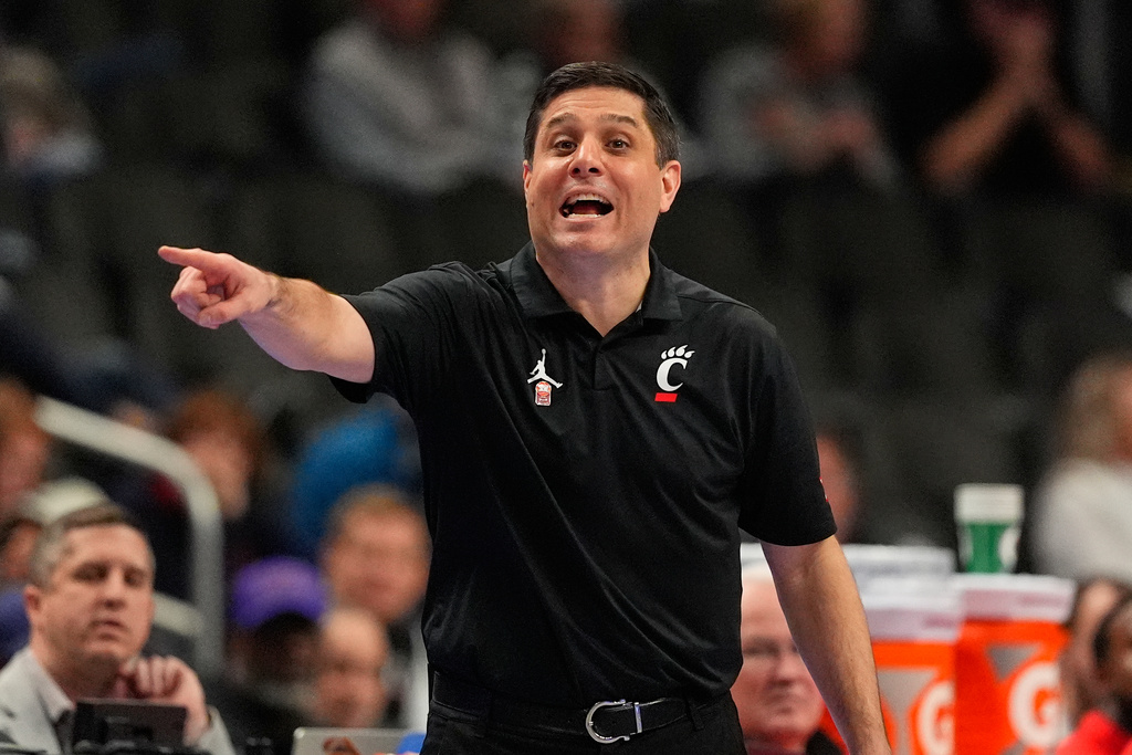 Cincinnati head coach Wes Miller is seen on the sidelines during the first half of an NCAA college basketball game against UCF in the second round of the Big 12 Conference tournament Wednesday, March 11, 2026, in Kansas City, Mo. (AP Photo/Charlie Riedel)