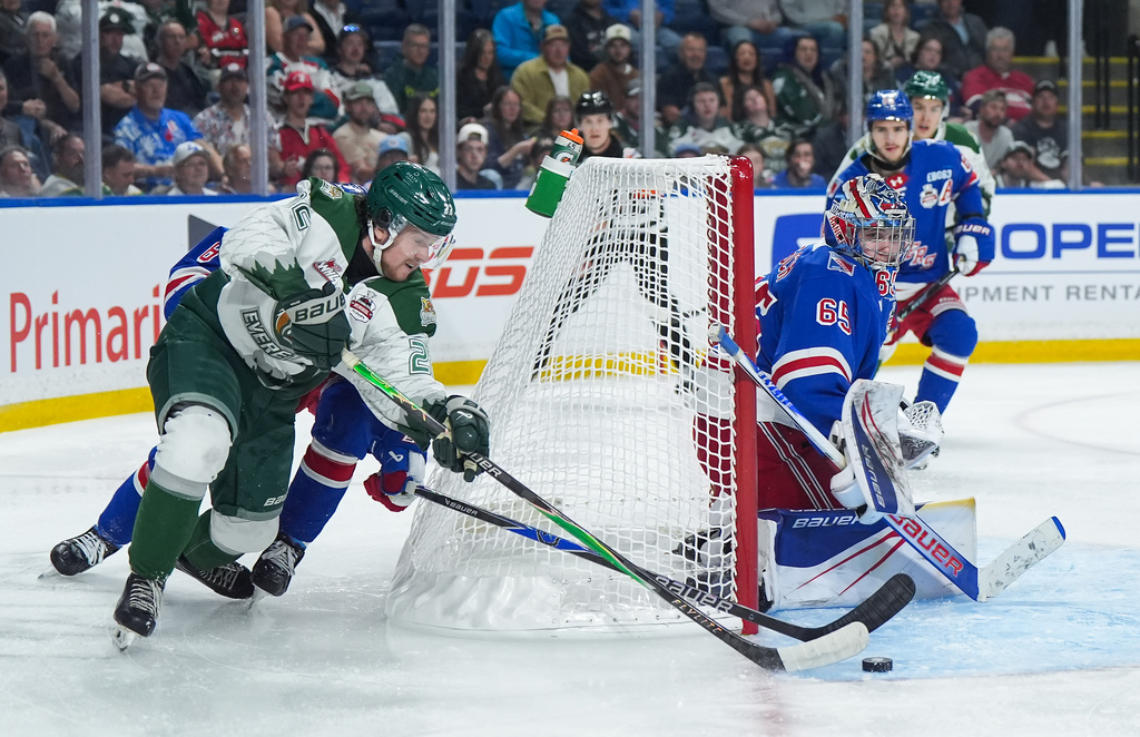 Everett Silvertips' Jesse Heslop, front left, attempts a wraparound against Kitchener Rangers goalie Christian Kirsch (65) during the first period of a Memorial Cup hockey game in Kelowna, British Columbia, Monday, May 25, 2026. (Darryl Dyck/The Canadian Press via AP)