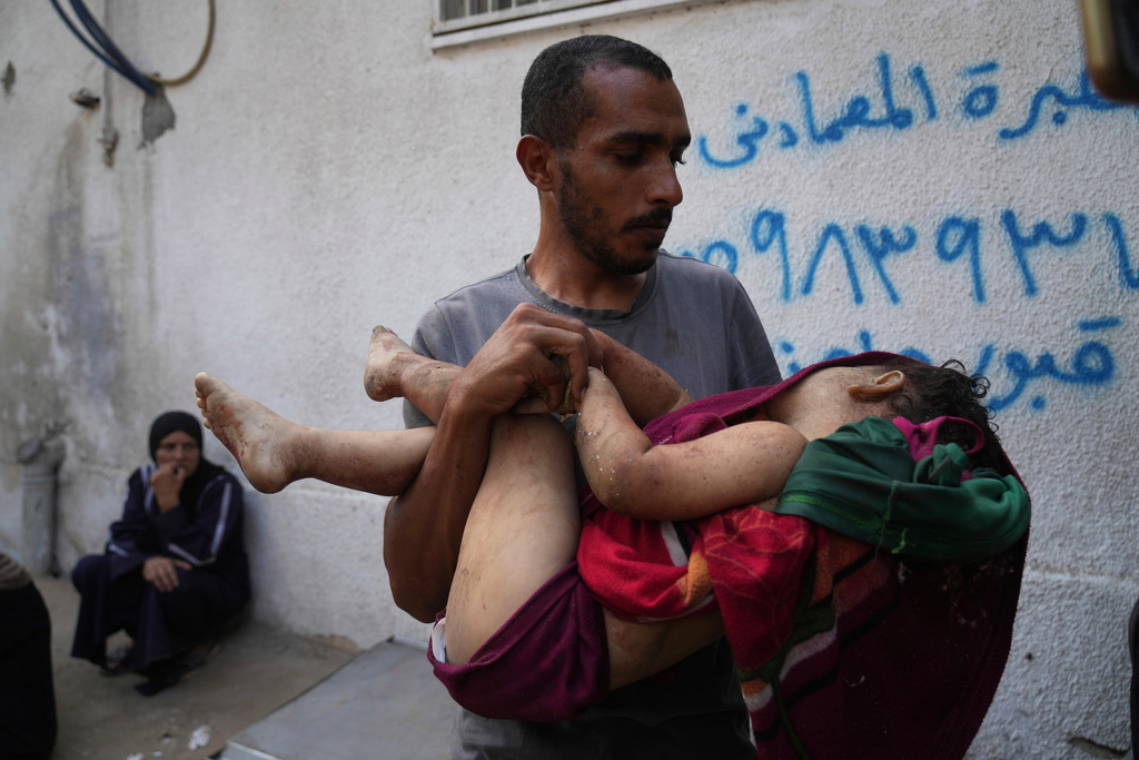 Alaa Hassanein carries the body of his 4-year-old niece, Sara Hassanein, who was killed in an Israeli military strike on a school used as a shelter, outside Al-Shifa Hospital, in Gaza City, Friday, Aug. 22, 2025. (AP Photo/Abdel Kareem Hana)