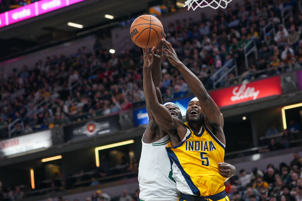 Indiana Pacers forward Jarace Walker, right, battles for a rebound with Boston Celtics center Neemias Queta, left, during the first half of an NBA basketball game in Indianapolis, Friday, Dec. 26, 2025. (AP Photo/AJ Mast)