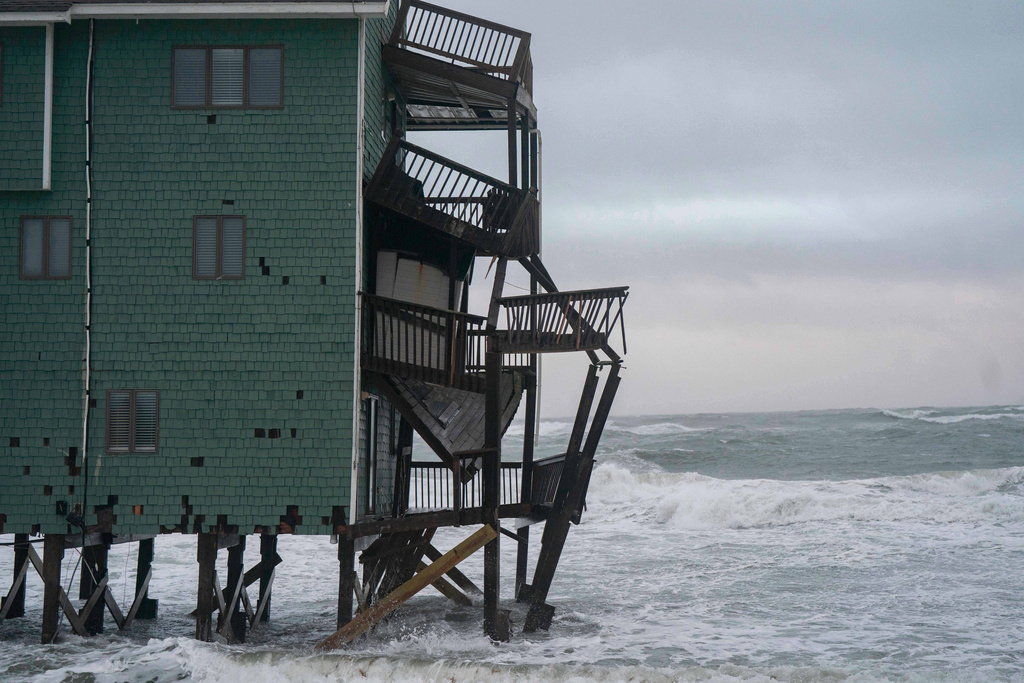 A house at risk of collapse is seen in the midst of a storm, Sunday, Oct. 12, 2025, in Buxton, N.C. (AP Photo/Allison Joyce)