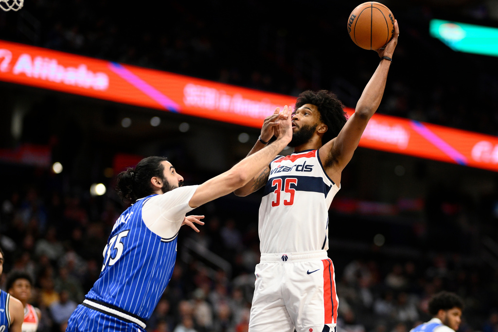 Washington Wizards forward Marvin Bagley, right, gets fouled by Orlando Magic center Goga Bitadze, left, during the first half of an NBA basketball game, Tuesday, Jan. 6, 2026, in Washington. (AP Photo/Nick Wass)