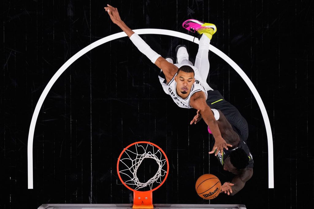 San Antonio Spurs forward Julian Champagnie, right, is blocked by San Antonio Spurs forward Victor Wembanyama, left, as he drives to the basket during the second half in Game 2 of a second-round NBA playoffs basketball series in San Antonio, Wednesday, May 6, 2026. (AP Photo/Eric Gay)