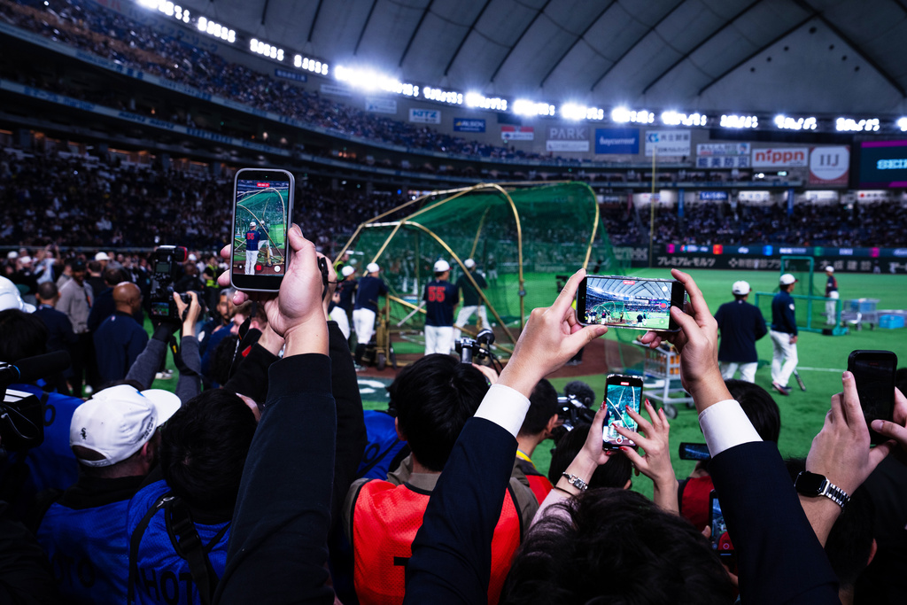 Media persons use mobile phones to photograph Japan's Shohei Ohtani practicing in the nets before the start of a World Baseball Classic Pool C game between Japan and Taiwan Friday, March 6, 2026 in Tokyo. (AP Photo/Louise Delmotte)