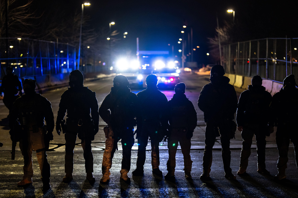FILE - Federal officers stand guard after detaining people outside of Bishop Henry Whipple Federal Building, Jan. 13, 2026, in Minneapolis. (AP Photo/Adam Gray, File)