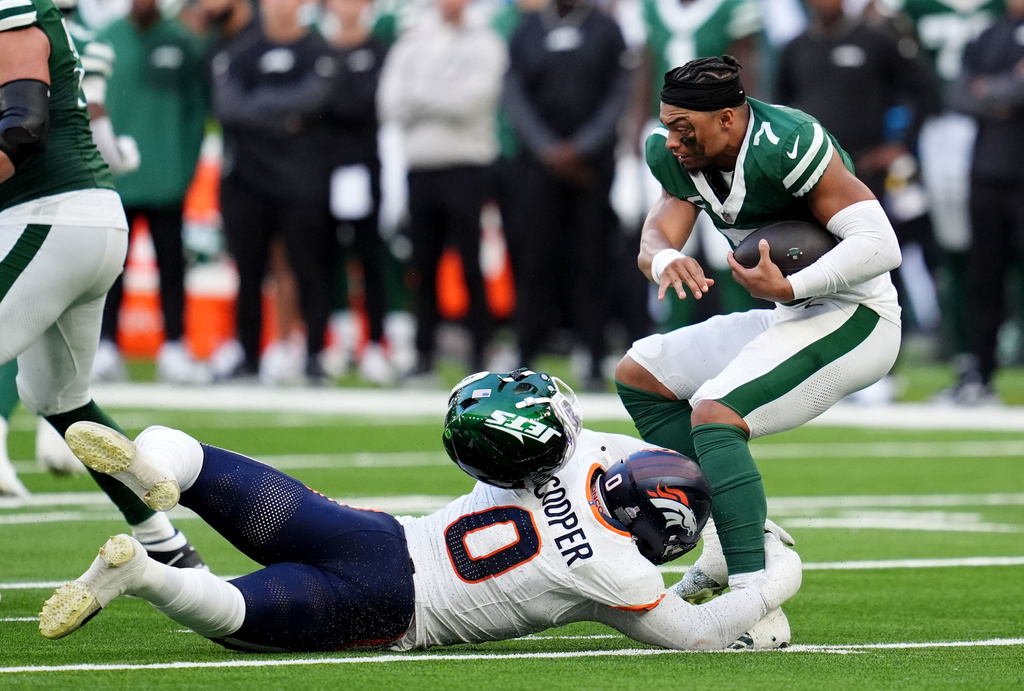 New York Jets quarterback Justin Fields (7) loses his helmet after he was tackled by the Broncos Jonathon Cooper in the second half of an NFL football game between the Denver Broncos and the New York Jets, Sunday, Oct. 12, 2025, in London. (Adam Davy/PA via AP)