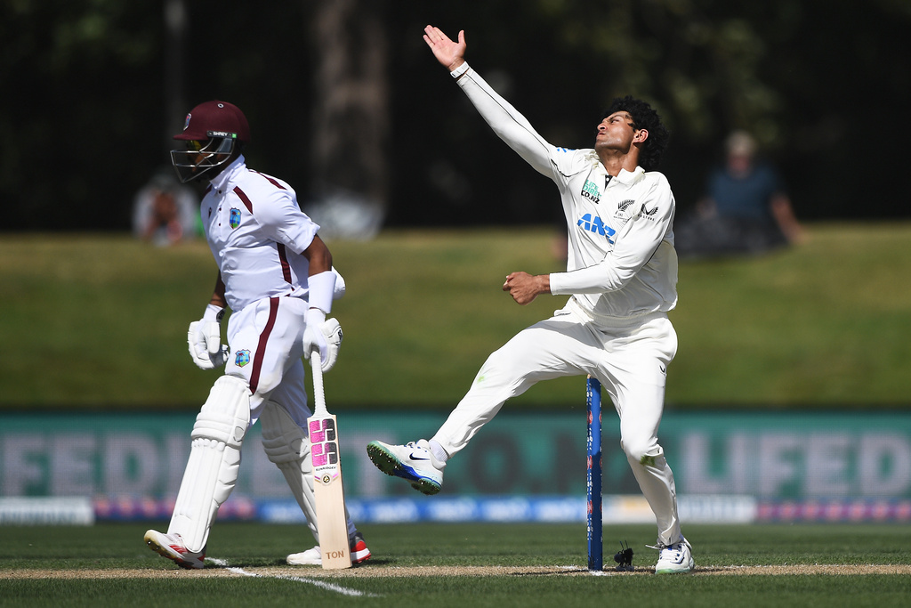 New Zealand's Rachin Ravindra, right, bowls as West Indies' Justin Greaves prepares to run on Day 4 of their cricket test match in Christchurch, New Zealand, Friday, Dec. 5, 2025. (Chris Symes/Photosport via AP)
