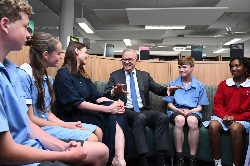 Australian Prime Minister Anthony Albanese, third right, gestures as he speaks to students and staff during a visit to St John Paul II College in Canberra, Australia, Thursday, Dec. 11, 2025. (Lukas Coch/AAP Image via AP)