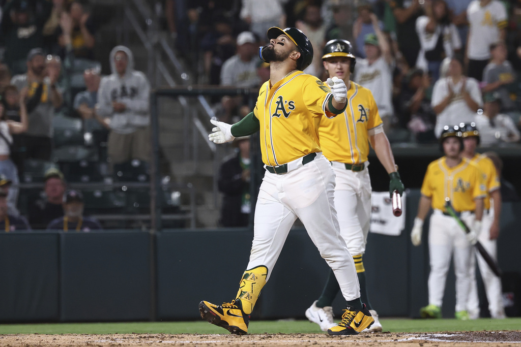 Athletics' Carlos Cortes, left, celebrates after hitting a solo home run during the third inning of a baseball game against the Cincinnati Reds, Friday, Sept. 12, 2025, in West Sacramento, Calif. (AP Photo/Sara Nevis)