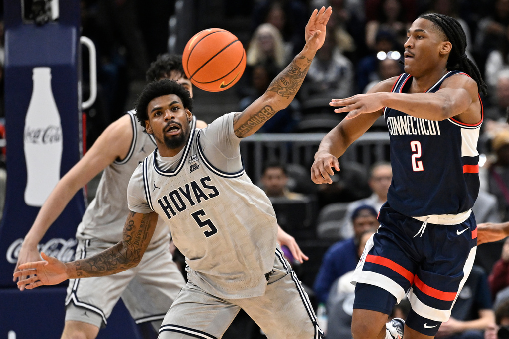UConn Huskies guard Silas Demary Jr. (2) passes off against Georgetown Hoyas guard KJ Lewis during the first half of an NCAA men's basketball game, Saturday, Jan. 17, 2026, in Washington. (AP Photo/John McDonnell)