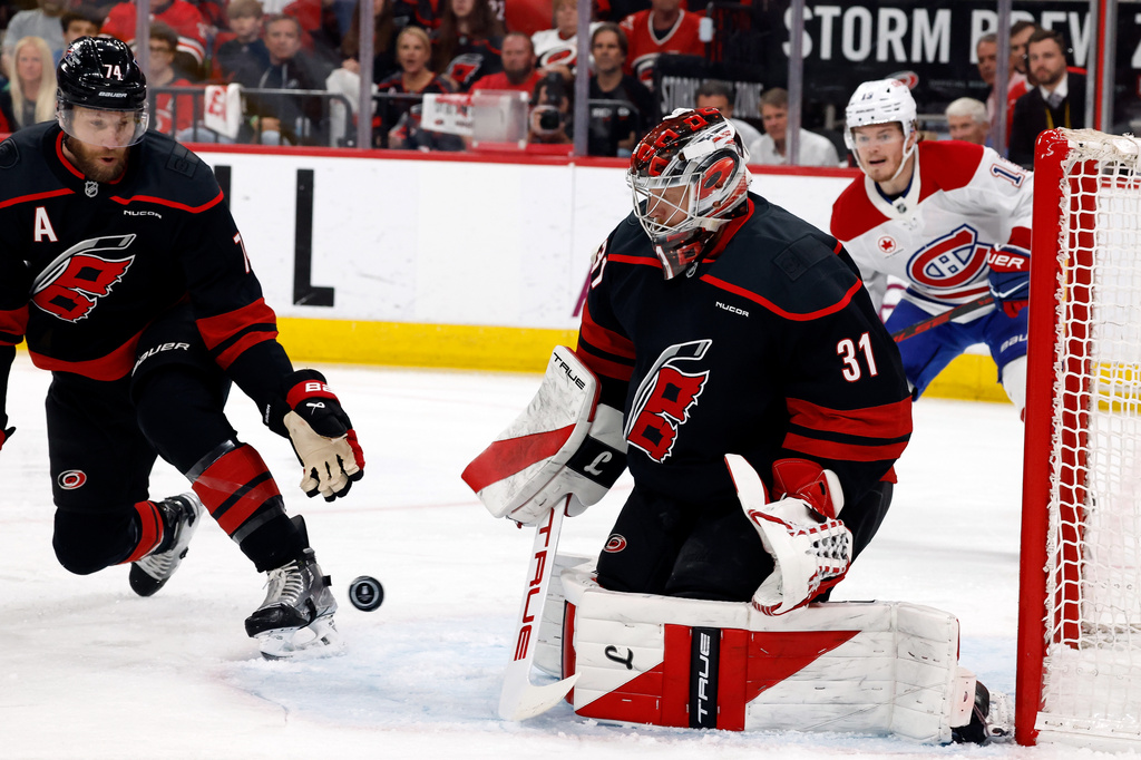 The puck bounces between Carolina Hurricanes goaltender Frederik Andersen (31) and Jaccob Slavin (74) with Montreal Canadiens' Cole Caufield (13) nearby during the first period in Game 5 of the Eastern Conference finals NHL hockey Stanley Cup playoff series in Raleigh, N.C., Friday, May 29, 2026. (AP Photo/Karl DeBlaker)