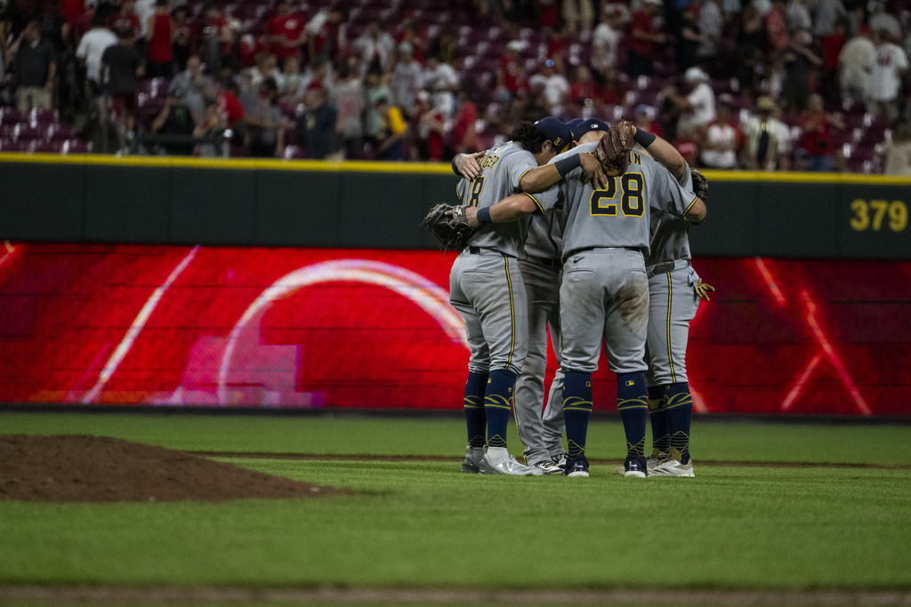The Milwaukee Brewers infield react after defeating the Cincinnati Reds in a baseball game, Saturday, Aug. 16, 2025, in Cincinnati. (AP Photo/Michael Swensen)