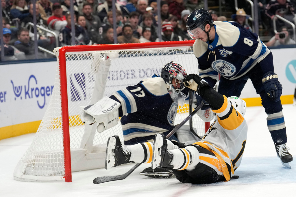 Pittsburgh Penguins right wing Bryan Rust (17) collides with Columbus Blue Jackets goaltender Jet Greaves (73) and the net as Columbus Blue Jackets defenseman Zach Werenski (8) is at right during the second period of an NHL hockey game, Friday, Nov. 28, 2025, in Columbus, Ohio. (AP Photo/Carolyn Kaster)