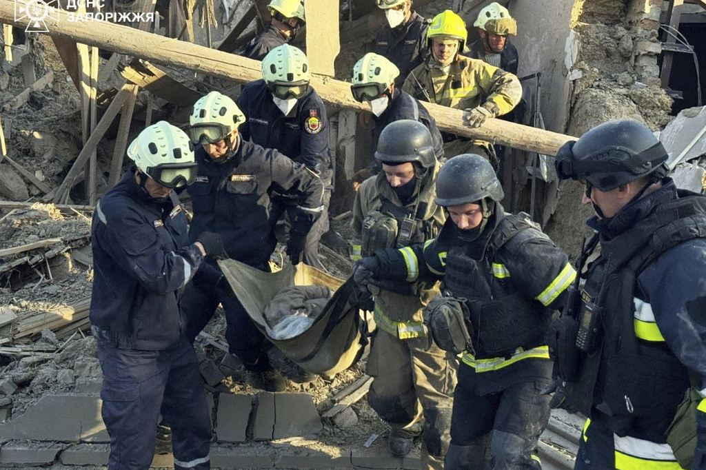 In this photo provided by the Ukrainian Emergency Service, firefighters carry a person after a Russian strike in Zaporizhzhia, Ukraine, Monday, Sept. 22, 2025. (Ukrainian Emergency Service via AP Photo)
