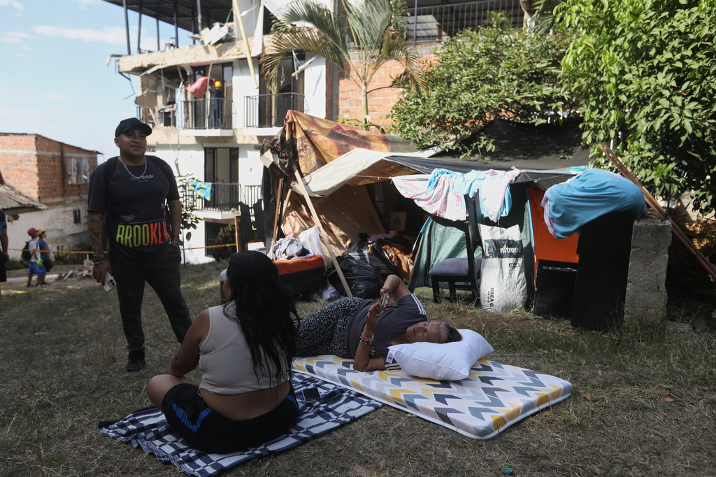 People camp on a soccer field near their earthquake-damaged homes three days after a quake hit Cali, Colombia, Thursday, Aug. 13, 2026. (AP Photo/Santiago Saldarriaga)