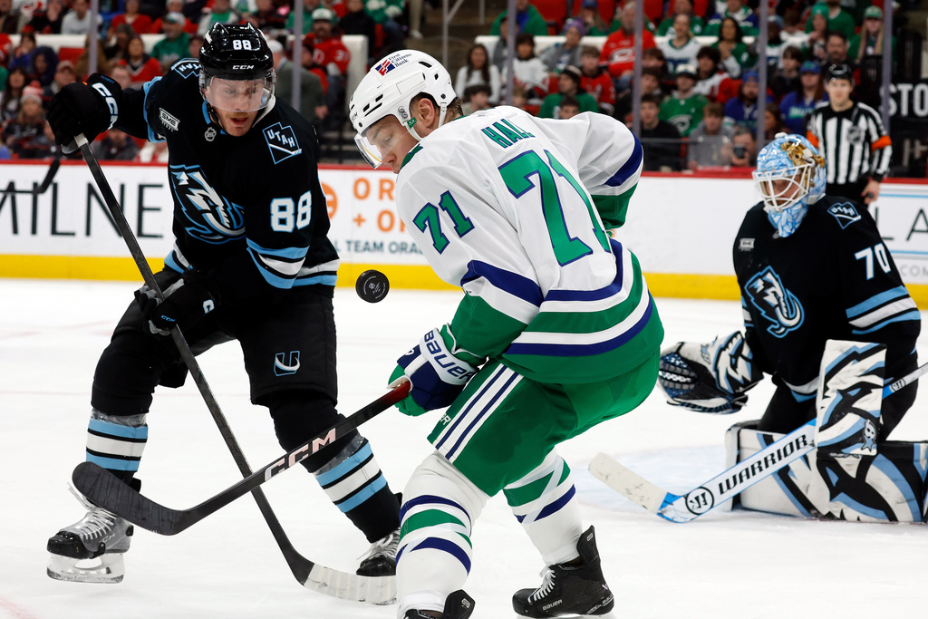 Carolina Hurricanes' Taylor Hall (71) watches the puck with Utah Mammoth's Nate Schmidt (88) nearby during the second period of an NHL hockey game in Raleigh, N.C., Thursday, Jan. 29, 2026. (AP Photo/Karl DeBlaker)