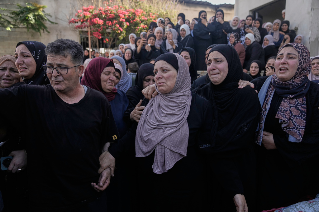 Mourners take the last look at the body of Palestinian Imad Haroun Ishtayeh, 26, who was shot and killed by Israeli forces on Sunday at a concrete barrier separating the occupied West Bank from Jerusalem, during his funeral in the village of Salem, east of Nablus, Sunday, May 31, 2026. (AP Photo/Majdi Mohammed)