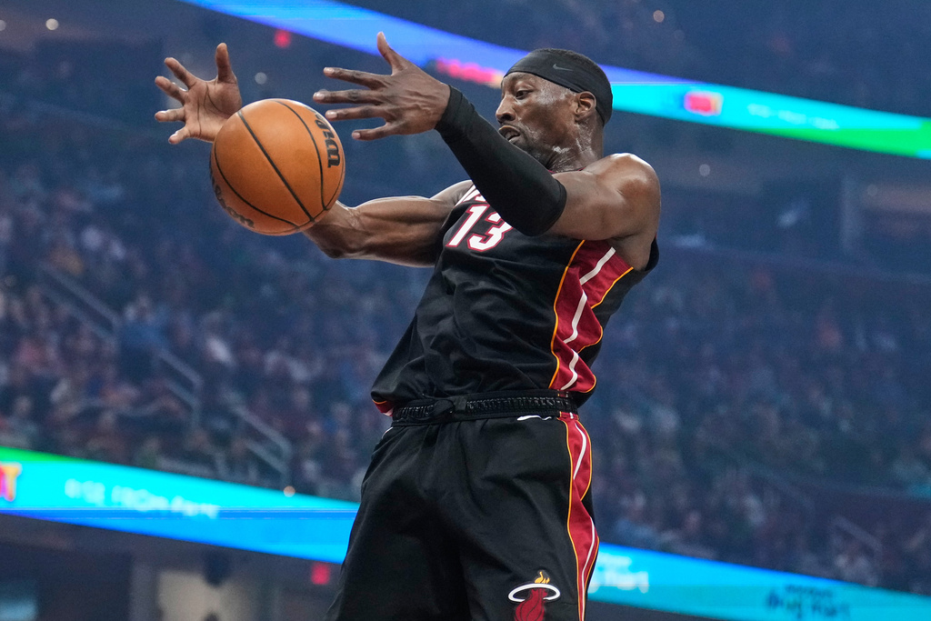 Miami Heat center Bam Adebayo (13) grabs a rebound in the first half of an NBA basketball game against the Cleveland Cavaliers in Cleveland, Wednesday, March 25, 2026. (AP Photo/Sue Ogrocki)