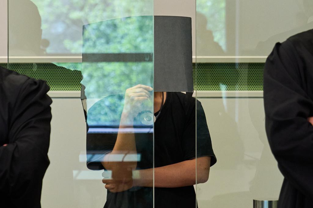 The defendant covering his face in the court during a trial against an online predator network of men accused of using chat groups to share tips on how to drug and rape women, in Berlin, Germany, Wednesday, July 8, 2026. (AP Photo/Ebrahim Noroozi)