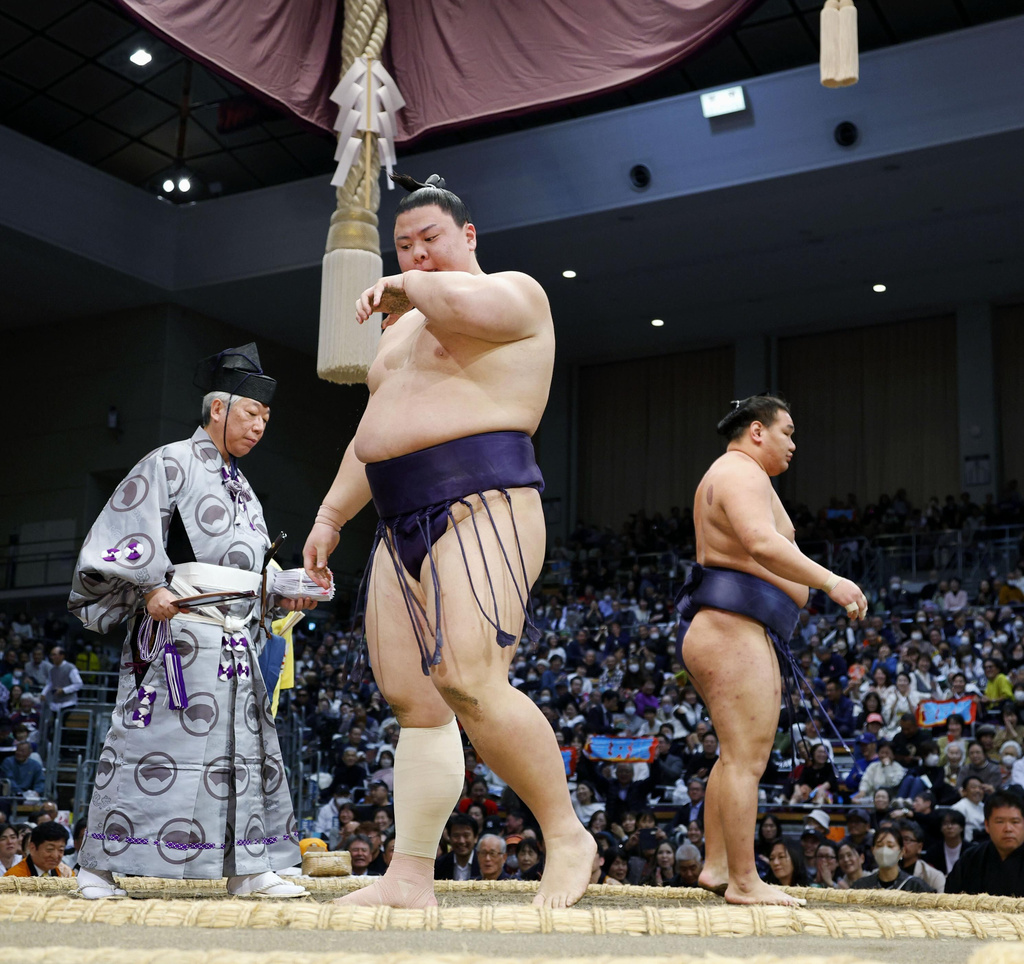 Sumo wrestler Yoshinofuji, center, reacts after being beaten by Yokozuna Hoshoryu during their bout at the Kyushu Grand Sumo Tournament in Fukuoka, southern Japan on Nov. 17, 2025. (Kotaro Ueda/Kyodo News via AP)