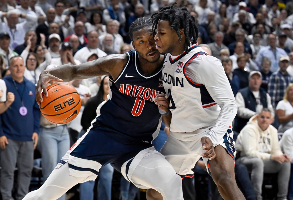 Arizona guard Jaden Bradley (0) is guarded by UConn guard Malachi Smith in the second half of an NCAA college basketball game, Wednesday, Nov. 19, 2025, in Storrs, Conn. (AP Photo/Jessica Hill)