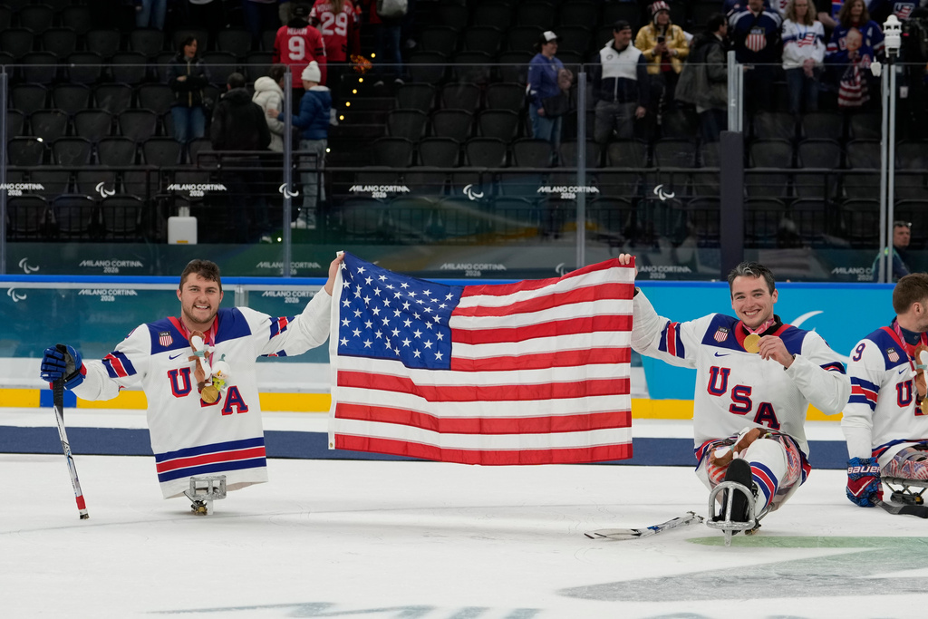 United States's Brody Roybal and his teammate Jack Wallace celebrate on the podium after winning the gold medal at the ice hockey of the 2026 Winter Paralympics, in Milan, Italy, Sunday, March 15, 2026. (AP Photo/Luca Bruno)
