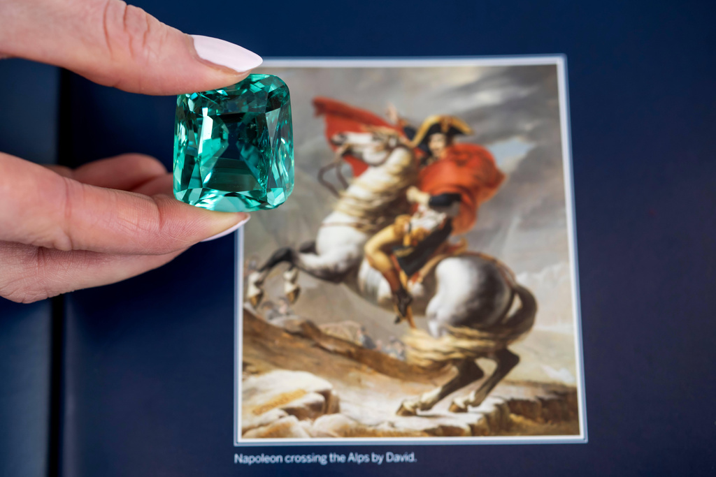 A Sotheby's employee displays a green beryl, over 132 carats, which Napoleon was said to have worn at his 1804 coronation, during a preview at Sotheby's in Geneva, Switzerland, Thursday Nov. 6, 2025. The jewel sold for a hammer price of 838,000 francs. (Martial Trezzini/Keystone via AP)