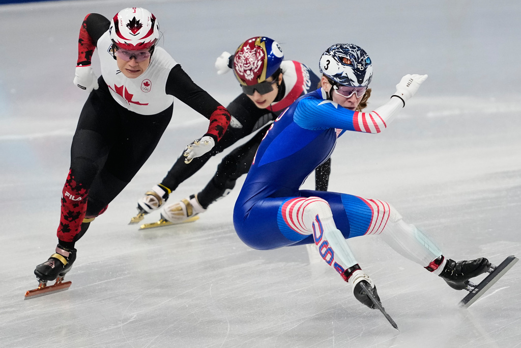 Corinne Stoddard, right, of the United States crashes as Courtney Sarault of Canada avoids her while competing in the team mixed relay short track speed skating at the 2026 Winter Olympics, in Milan, Italy, Tuesday, Feb. 10, 2026. (AP Photo/Ashley Landis)