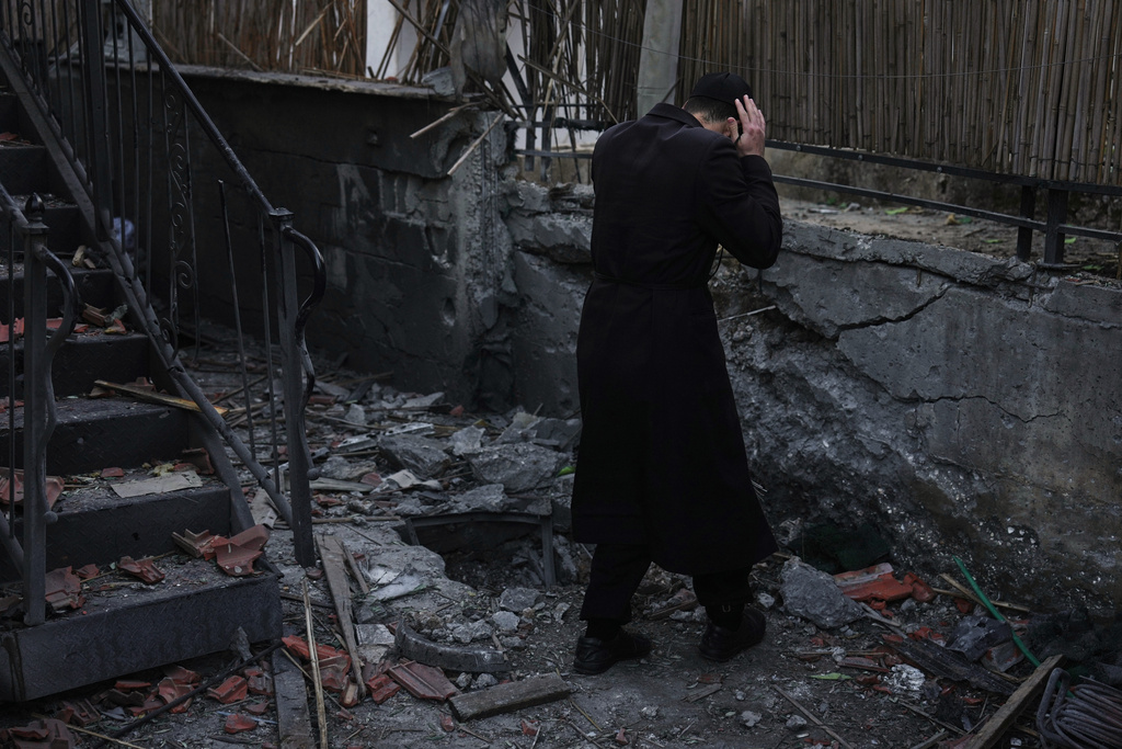 A man inspects a damaged house struck by a rocket fired from Lebanon, in Hatzor HaGlilit, northern Israel, Wednesday, March 4, 2026. (AP Photo/Ariel Schalit)