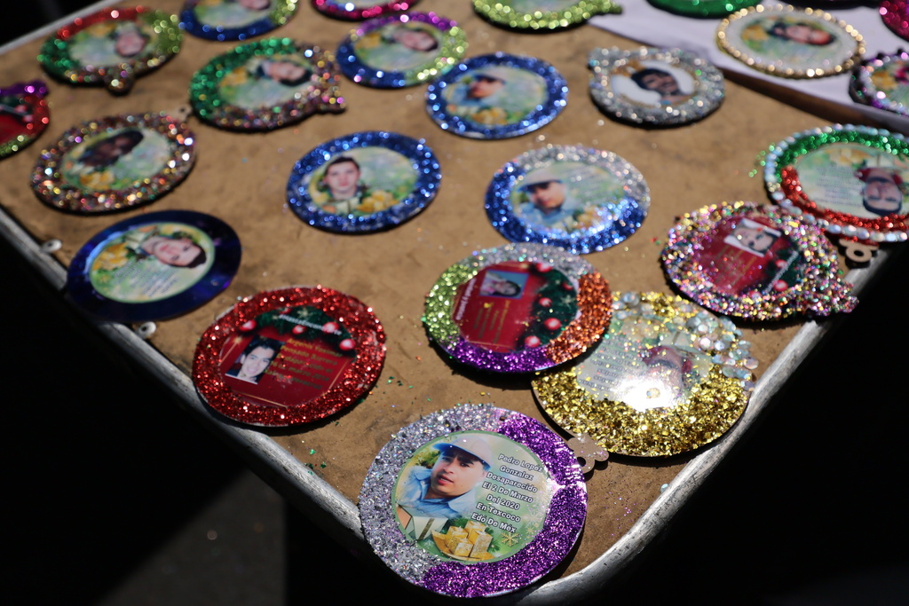 Christmas ornaments with photographs of the missing sit to dry before hanging on the Tree of Hope during an event organized by the diocese of Ecatepec at the Church of the Sacred Heart of San Cristobal in Ecatepec, State of Mexico, Monday, Nov. 17, 2025. (AP Photo/Ginnette Riquelme)