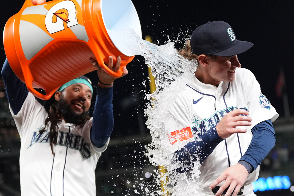Seattle Mariners' Colt Emerson, right, is doused by teammate J.P. Crawford, left, to celebrate a win over the Chicago White Sox in a baseball game, Monday, May 18, 2026, in Seattle. (AP Photo/Lindsey Wasson)