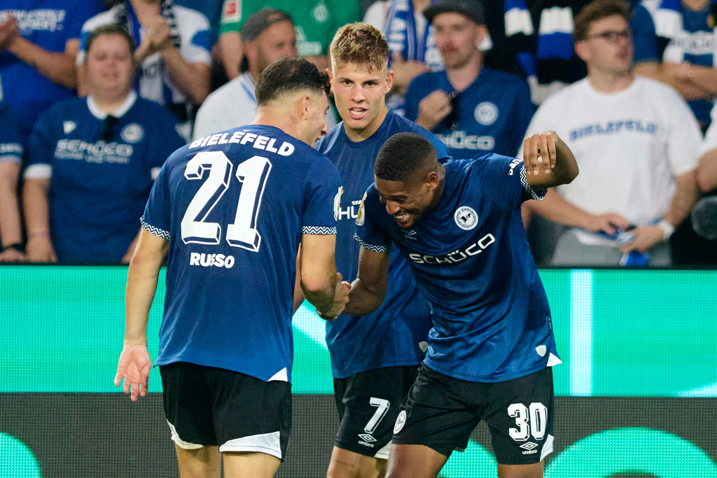 Bielefeld's Isaiah Young celebrates scoring with Stefano Russo, left, during the DFB Cup 1st round soccer match between Arminia Bielefeld and Werder Bremen at Schüco Arena, Bielefeld, Germany, Friday Aug. 15, 2025. (Bernd Thissen/dpa via AP)