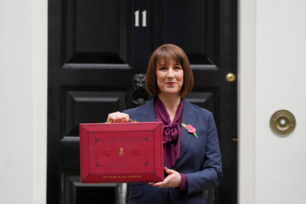 FILE - Britain's Chancellor of the Exchequer, Rachel Reeves, holds up the traditional red ministerial box containing her budget speech, as she poses for the media outside No 11 Downing Street, before departing to the House of Commons to deliver the budget in London, Wednesday, Oct. 30, 2024. (AP Photo/Kirsty Wigglesworth, File)