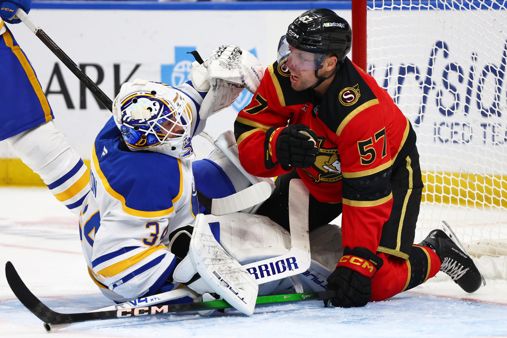 Ottawa Senators left wing David Perron (57) collides with Buffalo Sabres goaltender Alex Lyon (34) during the second period of an NHL hockey game Wednesday, Oct. 15, 2025, in Buffalo, N.Y. (AP Photo/Jeffrey T. Barnes)