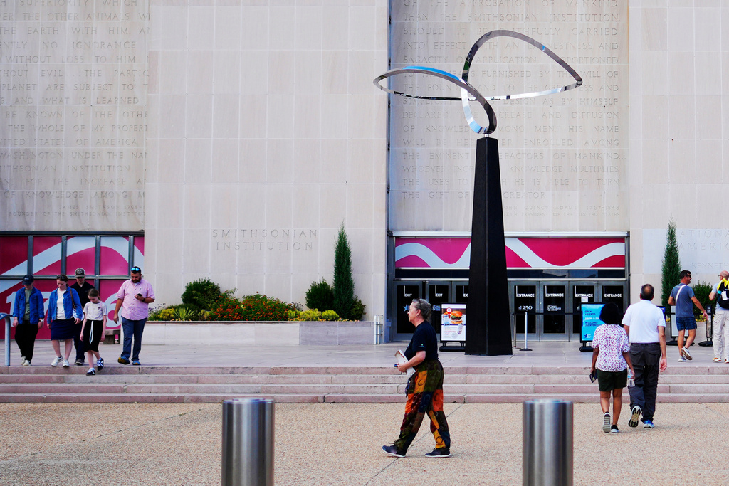 People walking past the "Infinity" sculpture outside the Smithsonian National Museum of American History on the National Mall in Washington, Tuesday, Sept. 8, 2026. (AP Photo/Pablo Martinez Monsivais)