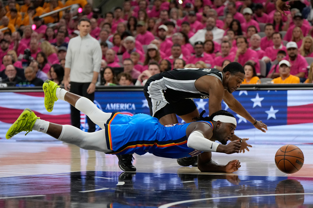 Oklahoma City Thunder guard Luguentz Dort, front, and San Antonio Spurs guard De'aaron Fox compete for the ball during the second half of Game 3 in the Western Conference finals NBA basketball playoffs series Friday, May 22, 2026, in San Antonio. (AP Photo/Ashley Landis)