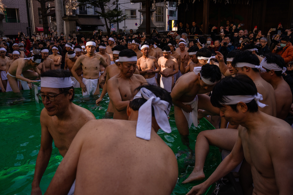 Participants bathe in ice-cold water to purify their souls and pray for good health during a New Year's ritual at Teppozu Inari Shrine in Tokyo, Sunday, Jan. 11, 2026. (AP Photo/Louise Delmotte)